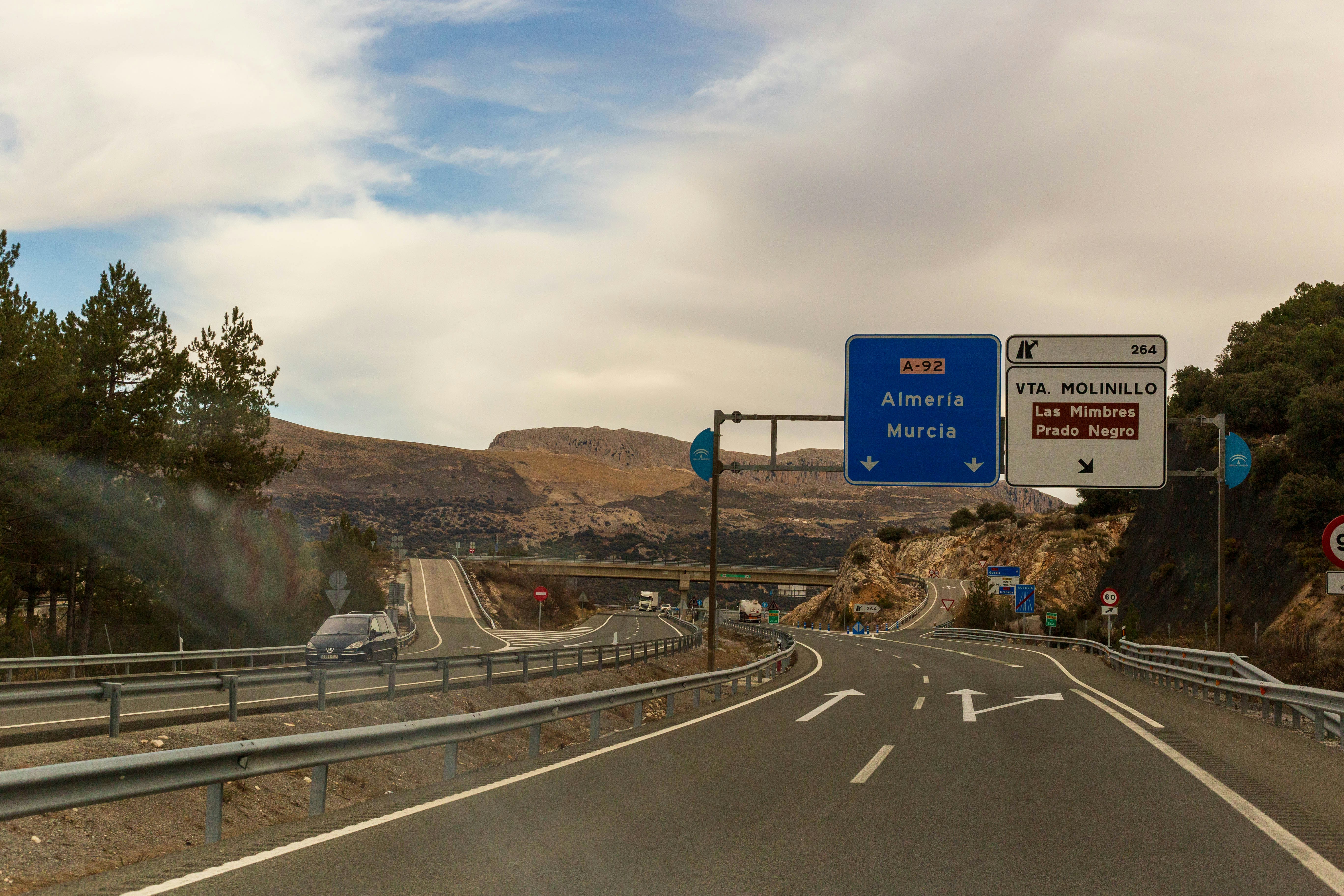 Highway scene with a green Murcia road sign on the autopista, cars passing under a clear sky